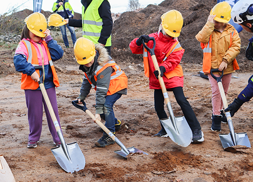 Fyra barn står med varsin spade och gräver