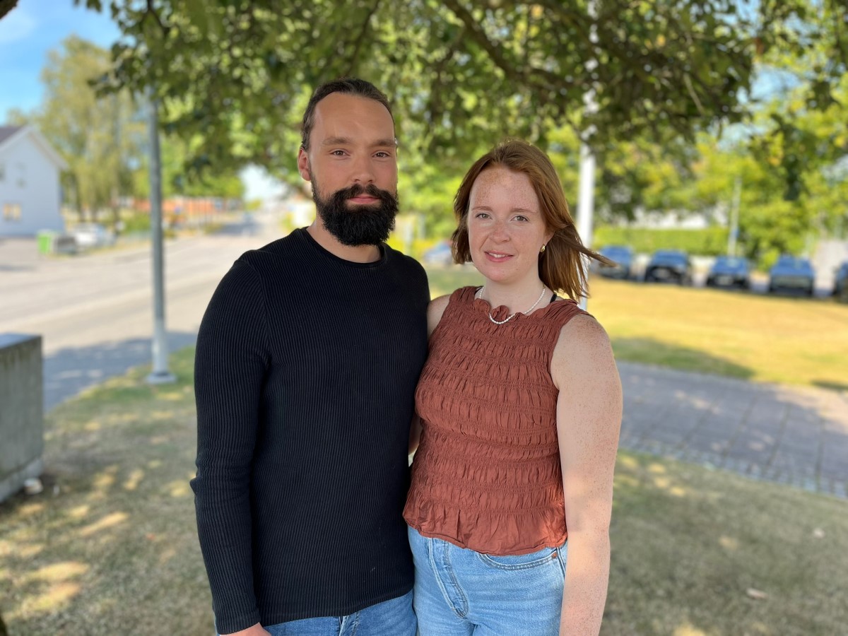 En man och en kvinna står framför ett träd.