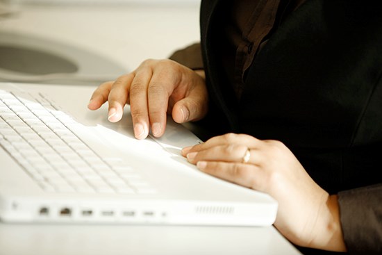 En person i svart tröja använder datorn