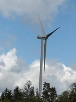 Foto på ett vindkraftverk mot blå himmel