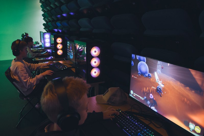 Tre unga killar som spelar vid var sin dator