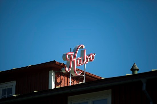 Neonskylt på ett hustak med ordet Habo.