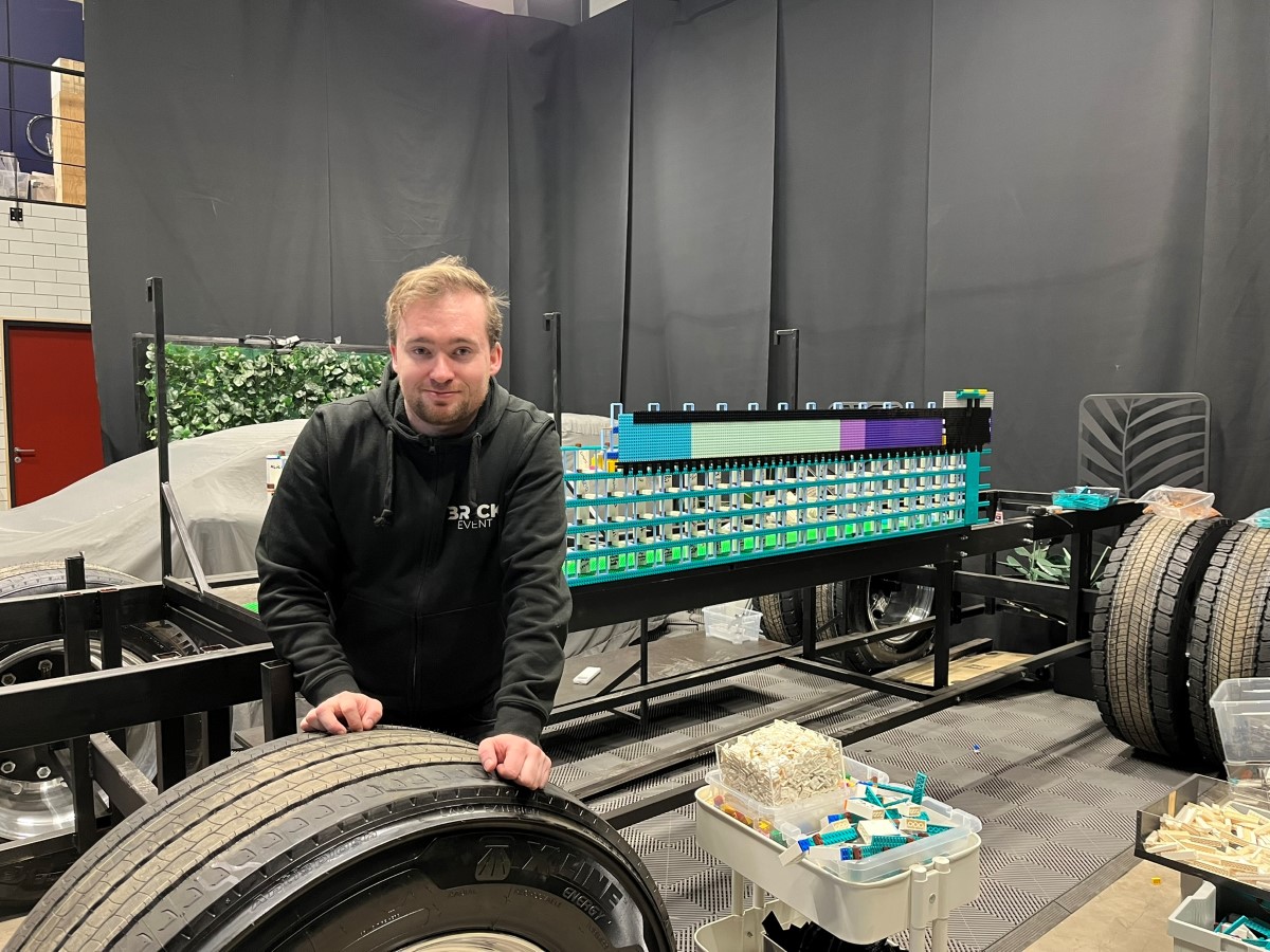 En man står framför en blivande lastbil i lego.