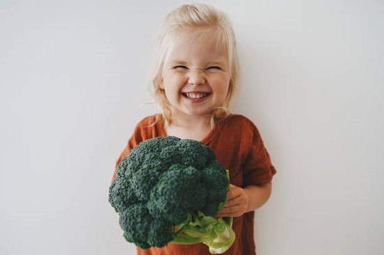 Flicka med broccoli.