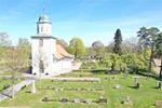 Vit kyrka med kyrkogård runtomkring.