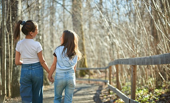 Två flickor som går i naturen.