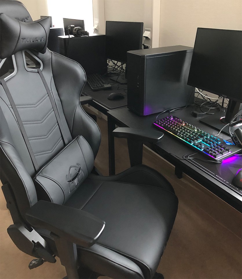 En gamingdator med skiftande färger på tangentbord och en stol avsedd för "gaming".
